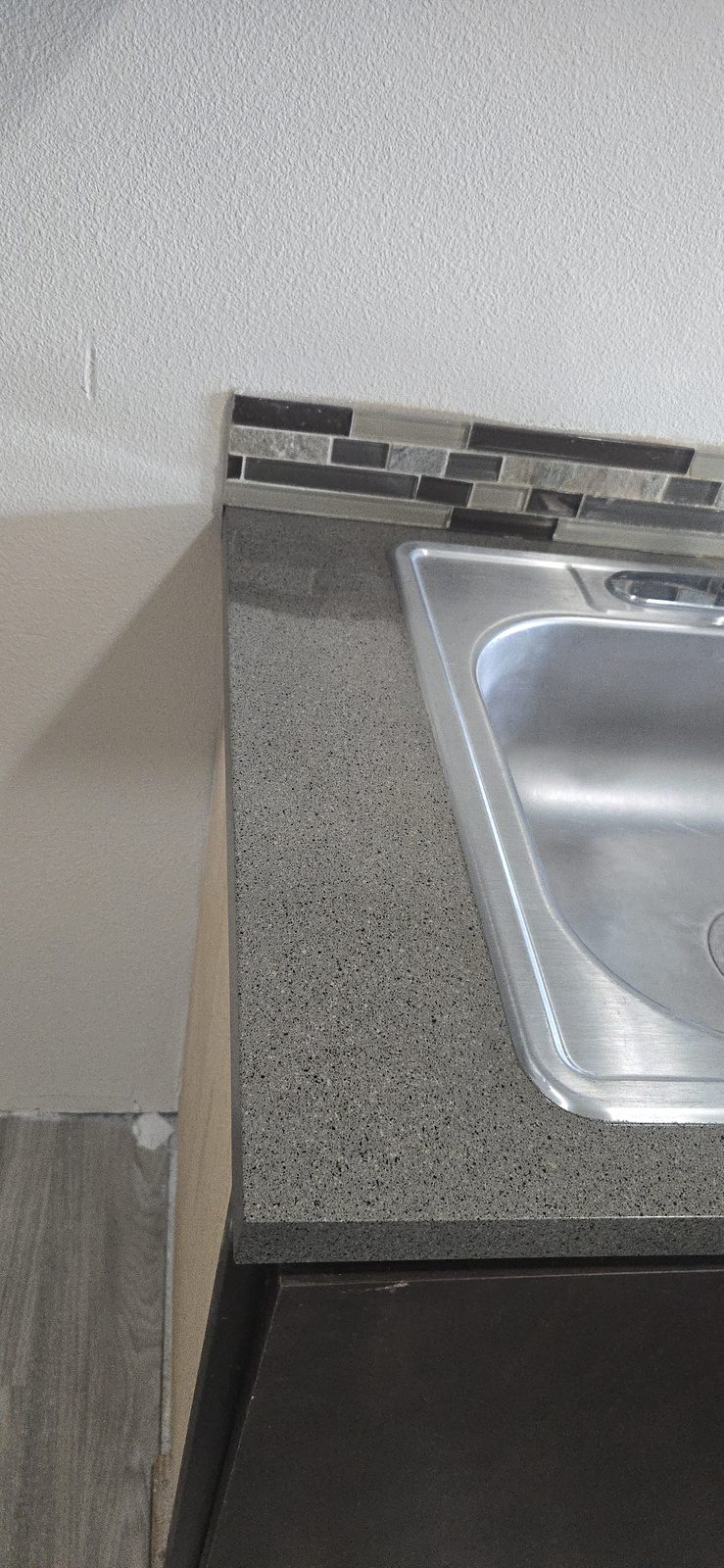 The same kitchen sink and countertop after resurfacing with a uniform granite-look finish