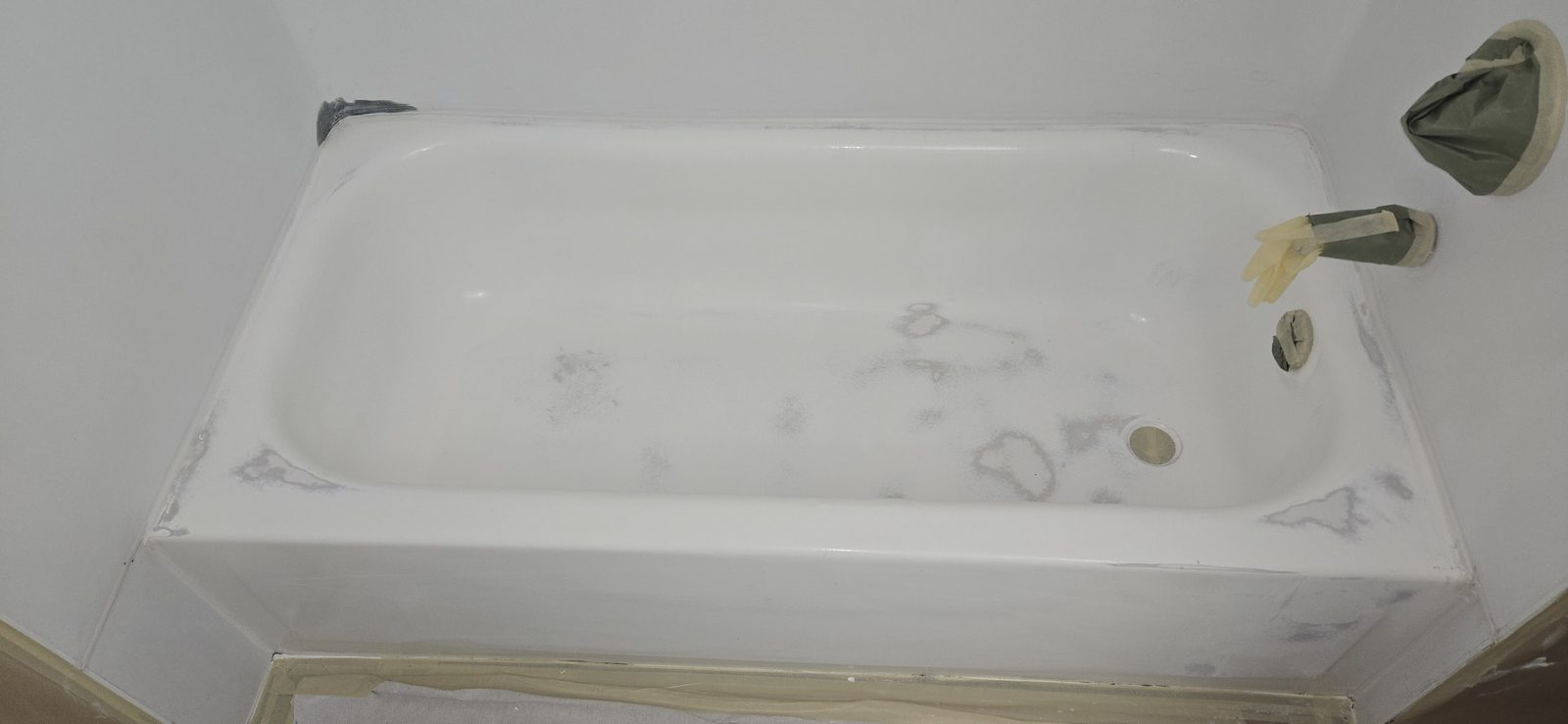 Bathtub surface before resurfacing, with a worn and marked finish